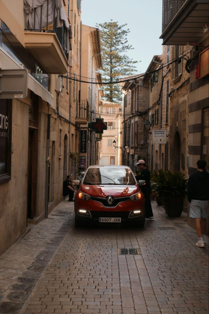 Car driving through narrow Mallorca old town street