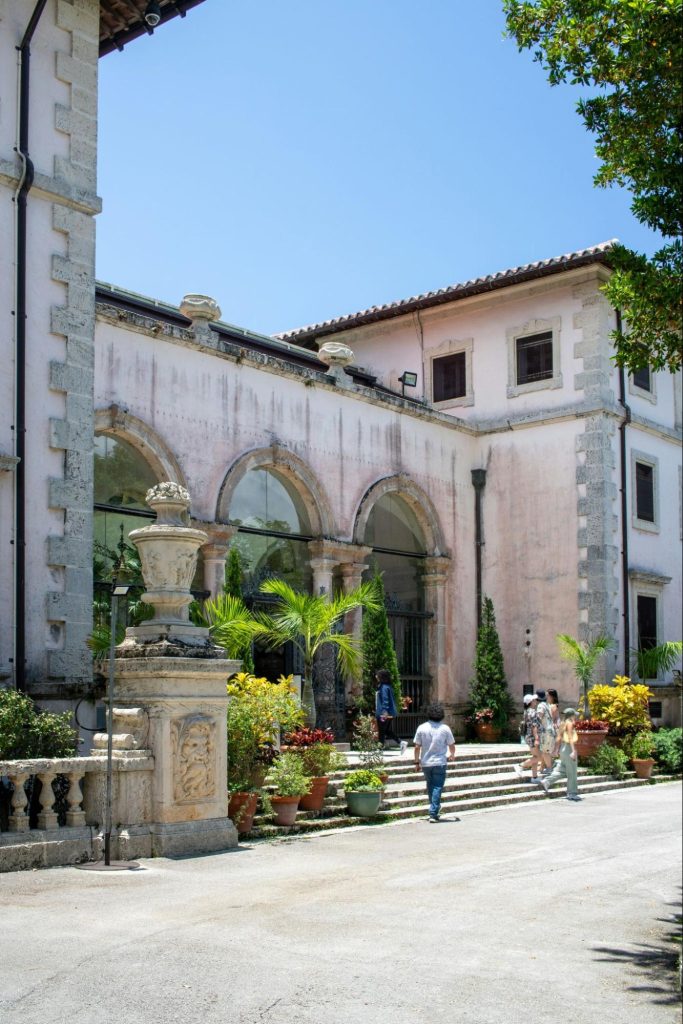 Visitors walking through Vizcaya Museum garden courtyard