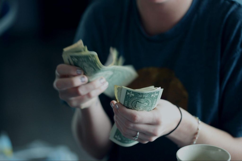 Traveler counting US dollars while planning trip budget